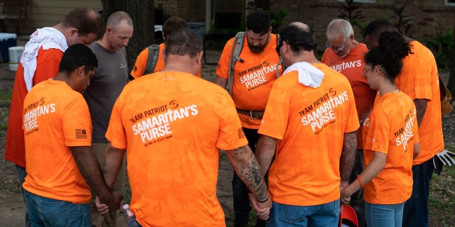 Team Patriot members pray after a day spent installing bathrooms, repairing windows and laying trim at a home devastated by Hurricane Harvey.