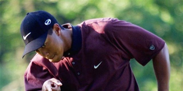 FILE - In this Aug. 20, 2000 file photo, Tiger Woods points to his ball as it drops for birdie on the first hole of a three-hole playoff against Bob May at the PGA Championship at the Valhalla Golf Club in Louisville, Ky. On his web site Friday night, Dec. 11, 2009, Woods announced that he is taking an indefinite break from professional golf. (AP Photo/Chuck Burton, File)