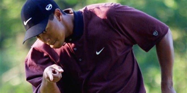 FILE - In this Aug. 20, 2000 file photo, Tiger Woods points to his ball as it drops for birdie on the first hole of a three-hole playoff against Bob May at the PGA Championship at the Valhalla Golf Club in Louisville, Ky. On his web site Friday night, Dec. 11, 2009, Woods announced that he is taking an indefinite break from professional golf. (AP Photo/Chuck Burton, File)