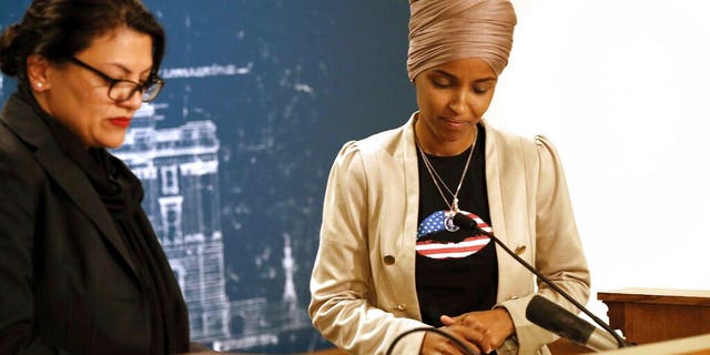 Rep. Ilhan Omar, D-Minn., right, and Rep. Rashida Tlaib, D-Mich., take a quiet moment as they talked about Israel's refusal to allow them to visit the country during a news conference Monday, Aug. 19, 2019 at the State Capitol in St. Paul, Minn. (AP Photo/Jim Mone)