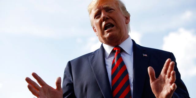 President Donald Trump speaks with reporters before boarding Air Force One with first lady Melania Trump at Morristown Municipal Airport in Morristown, N.J., Sunday, Aug. 18, 2019. (AP Photo/Patrick Semansky)