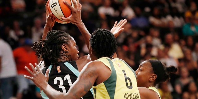 Seattle Storm forward Natasha Howard, right, defends New York Liberty center Tina Charles, left, who looks to pass during the first half of a WNBA basketball game, Sunday, Aug. 11, 2019, in New York. (AP Photo/Kathy Willens)
