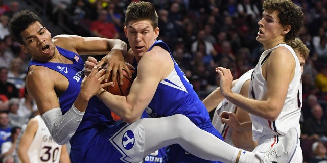Yoeli Childs #23, left, and Dalton Nixon #33 of the Brigham Young Cougars both try to grab a rebound as Evan Fitzner #21 of the Saint Mary's Gaels looks on during a semifinal game of the West Coast Conference basketball tournament at the Orleans Arena on March 5, 2018 in Las Vegas. (Photo by Ethan Miller/Getty Images)