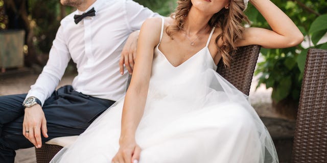 Newlywed coupe sitting on a sofa angry at each other in a middle of an argument. Young couple problem concept outdoor