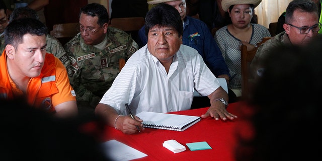 Bolivia's President Evo Morales, center, sits next to his Defense Minister Javier Zavaleta, left, during a meeting to discuss firefighting efforts in Robore, Bolivia, Tuesday, Aug. 27, 2019.