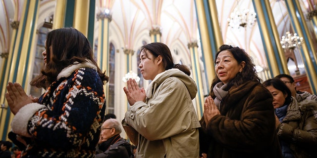 Chinese worshippers attend a Mass during Christmas Eve at a Catholic church in Beijing on December 24, 2018. (Photo by WANG ZHAO / AFP) (Photo credit should read WANG ZHAO/AFP/Getty Images)
