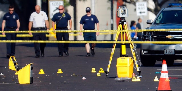 Evidence markers rest on the street at the scene of a mass shooting Sunday, Aug. 4, 2019, in Dayton, Ohio.