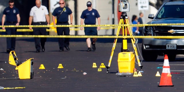 Evidence markers rest on the street at the scene of a mass shooting Sunday, Aug. 4, 2019, in Dayton, Ohio.