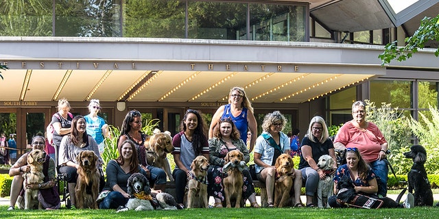 All the dogs and their training handlers outside the theater.