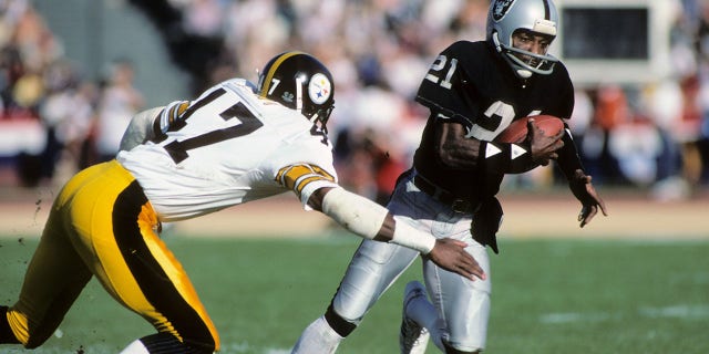 Cliff Branch, right, of the then-Los Angeles Raiders, runs the ball against Mel Blount of the Pittsburgh Steelers during an AFC playoff game in Los Angeles, Jan. 1, 1984. (Getty Images)