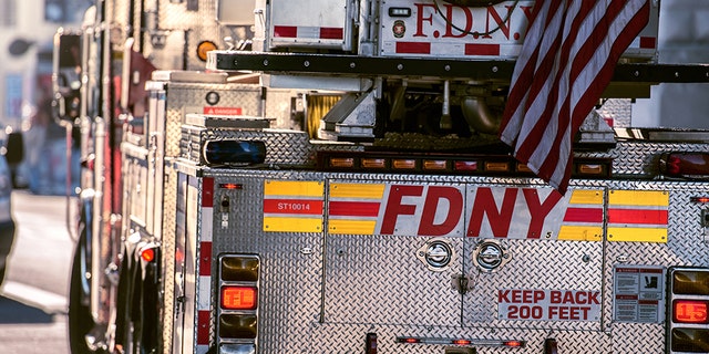 A Fire Department of New York Ladder truck going for rescue with firemen.