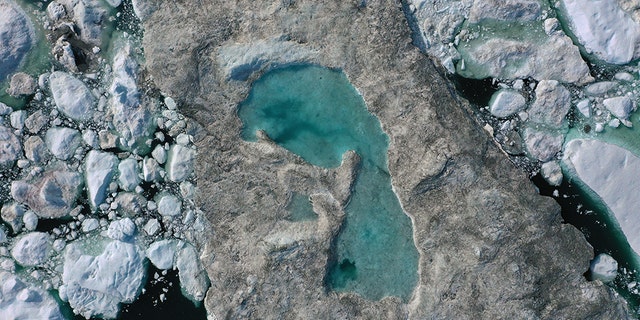 In this aerial view melting ice forms a lake on free-floating ice jammed into the Ilulissat Icefjord during unseasonably warm weather on July 30, 2019 near Ilulissat, Greenland. (Photo by Sean Gallup/Getty Images)