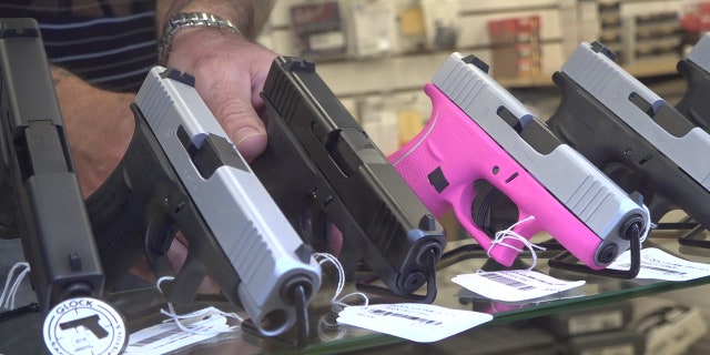 Handguns for sale in a display case at a licensed dealer in Arizona.