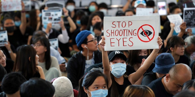 Protester holds up a placard during a sit-in protest at the arrival hall of the Hong Kong International Airport, a major hub in Asia, in Hong Kong on Aug. 12, 2019.