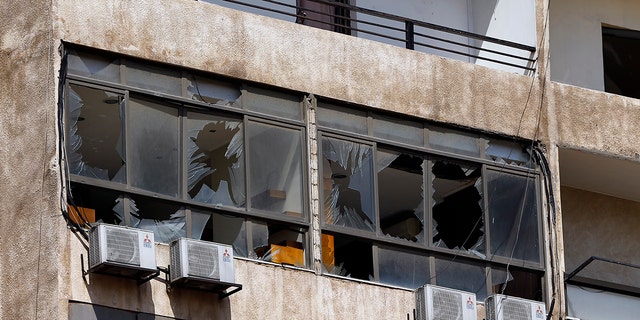 Broken windows are seen on the 11-floor building that houses the media office in a stronghold of the Lebanese Hezbollah group in a southern suburb of Beirut. (AP Photo/Bilal Hussein)