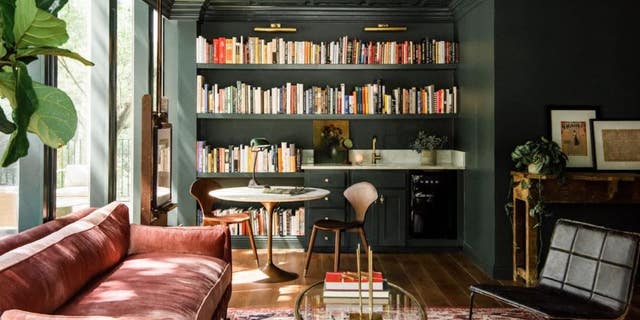 Joanna decided on a library and living room-type setting with dark green walls and eclectic furniture to really punch up her team’s creativity.
