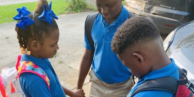 Jamisha Harris shared a photo of her children Eugene Jacobs, 10, Jorden Jacobs, 8, and Emily Jacobs, 7, praying before their first day of school.