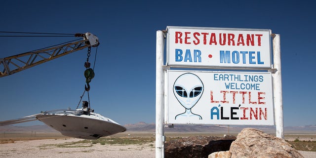Sign indicating Little A "The Inn" and a flying saucer suspended at a tow truck, Rachel, Nevada, near Area 51.