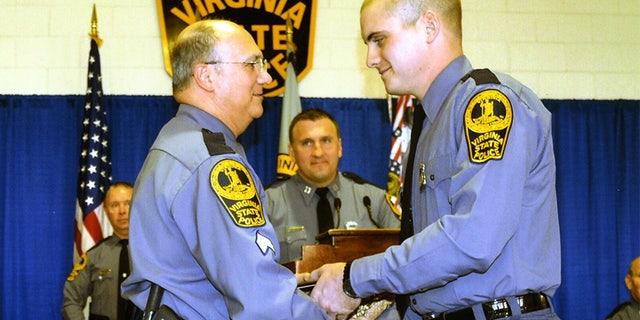 Sgt. Bob Carpentieri presenting Lucas Dowell his graduation certificate from the Virginia State Police academy.