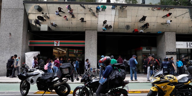 Journalists gather outside the federal mint's headquarters in Mexico City, Tuesday, Aug. 6, 2019. Mexican authorities say gunmen raided the federal mint's headquarters and took items from a vault.