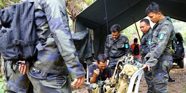 Members of General Operations Force work at a temporary operation shelter near The Dusun resort where a 15-year-old London girl went missing, in Seremban, Negeri Sembilan, Malaysia, Tuesday, Aug. 6, 2019. (AP Photo/Lai Seng Sin)