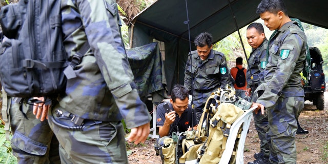 Members of General Operations Force work at a temporary operation shelter near The Dusun resort where a 15-year-old London girl went missing, in Seremban, Negeri Sembilan, Malaysia, Tuesday, Aug. 6, 2019. (AP Photo/Lai Seng Sin)