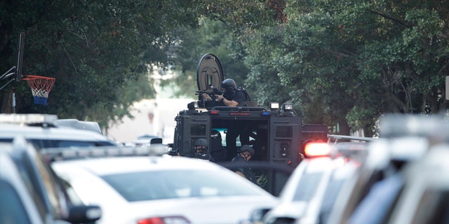 Aplicación de la ley con una pistola desenfundada en el barrio de Nicetown de Filadelfia.