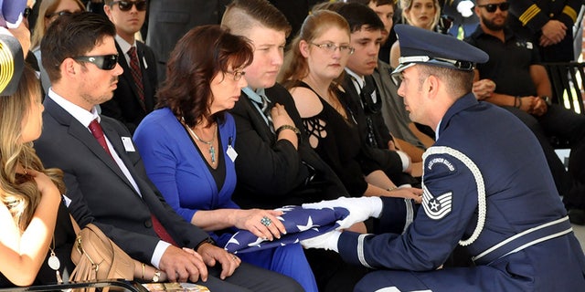 An American flag is presented to McKeithen's wife, Pamela, during a service at the Biloxi National Cemetery. McKeithen was an Air Force veteran.