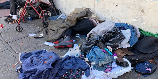 Sleeping people, discarded clothes and used needles are seen on a street in the Tenderloin neighborhood in San Francisco last month (AP)