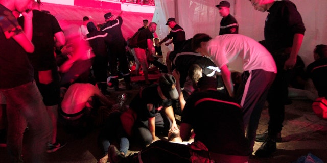 People are being tended by rescue workers during Algerian rap artist Abderraouf Derradji's concert, known as Soolking, at a stadium in Algiers, Thursday, Aug. 22, 2019. (AP Photo/Fateh Guidoum)