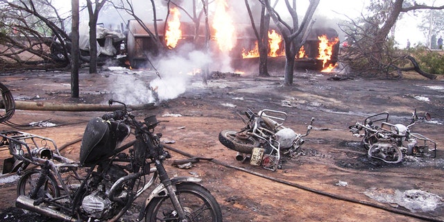Destroyed motorbikes and debris litter the scene as the tanker burns in the background. (AP Photo)