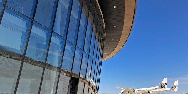 Virgin Galactic's carrier plane makes its way across the apron in front of Spaceport America following a test flight over its new permanent home near Upham, New Mexico, on Thursday, Aug. 15, 2019. Virgin Galactic on Thursday unveiled two levels of its new digs at the spaceport, which includes a social hub where crew, pilots and customers and their families can mingle. (AP Photo/Susan Montoya Bryan)