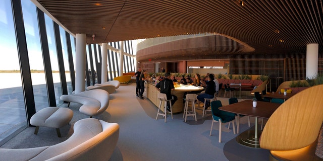 Virgin Galactic employees gather at the coffee bar that serves as the heart of the company's social hub where they will meet with customers and their families at Spaceport America once commercial operations begin near Upham, New Mexico, on Thursday, Aug. 15, 2019. Virgin Galactic unveiled some of the interior spaces of the custom-tailored terminal Thursday, saying the designs are aimed at connecting the customers with operations as they prepare for their suborbital flights. (AP Photos/Susan Montoya Bryan)