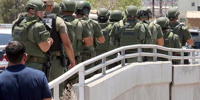 Law enforcement officers make their way along a walkway to the scene of a mass shooting at Walmart in El Paso, Texas. (AP)