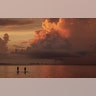Two paddle boarders stop to watch the sunrise on a stormy morning in Sanibel, Florida, Aug. 15, 2019. 