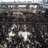 Protesters surround banners that read: "Those on the street today are all warriors!" and "Release all the detainees!" during a sit-in rally at the arrival hall of the Hong Kong International airport in Hong Kong, Aug. 12, 2019. 