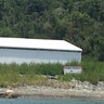 A white structure next to a red and write "private property" sign located just above the shorline on Little St. James Island. The island was purchased by Epstein 21 years ago. 