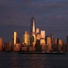 The skyline of lower Manhattan glows in gold as the sun sets in New York City, Aug 27, 2019.