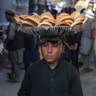 An Afghan boy carries bread for sale at a market in the old city of Kabul, Afghanistan, Aug. 1, 2019. 