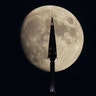 The moon rises behind the spire of One World Trade Center in New York City, Aug. 13, 2019.