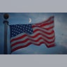 The moon rises over a flag at sunset in Jersey City, New Jersey, Aug. 6, 2019.