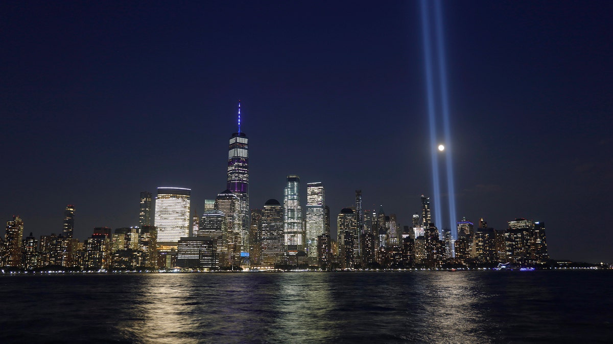 The moon passes through the annual Tribute in Light illuminated on the skyline of lower Manhattan on the 18th anniversary of the 9/11 attacks in New York City on Sept. 11, 2019 as seen from Jersey City, New Jersey. (Photo by Gary Hershorn/Getty Images)