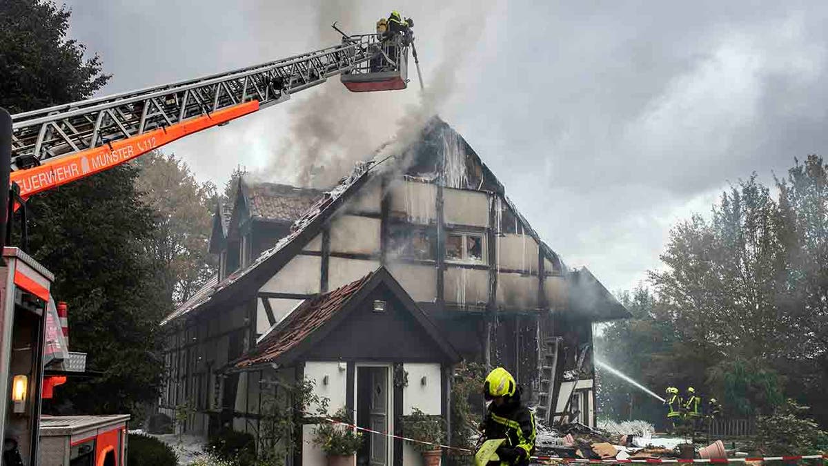 Firefighters extinguish a fire in a house in Muenster, Germany, Wednesday, Sept. 18, 2019. Two women and a police officer where injured by an explosion inside the house. (Bernd Thissen/dpa via AP)