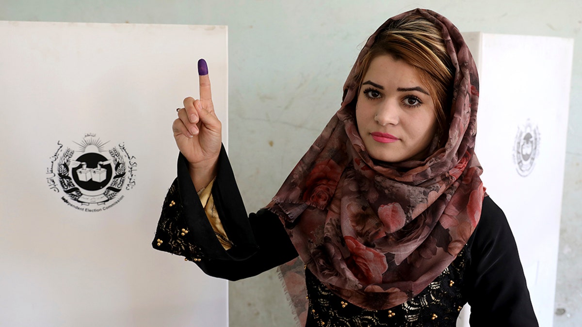 An Afghan woman shows her inked finger after casting her vote at a polling station in Kabul, Afghanistan, Saturday, Sept. 28, 2019. Afghans headed to the polls on Saturday to elect a new president amid high security and threats of violence from Taliban militants, who warned citizens to stay away from polling stations or risk being hurt. (AP Photo/Ebrahim Noroozi)