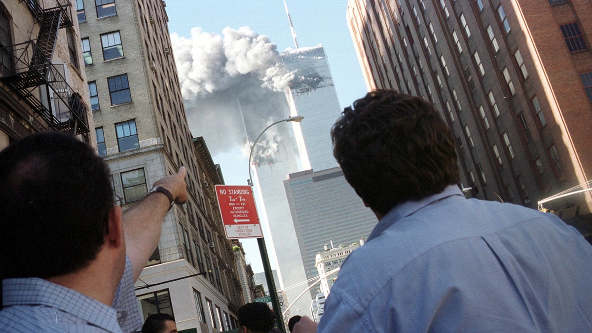 Pedestrians react to the World Trade Center collapse September 11, 2001. Two commercial airplanes crashed into the World Trade Center earlier.  REUTERS/Stringer - PBEAHUKXYAY