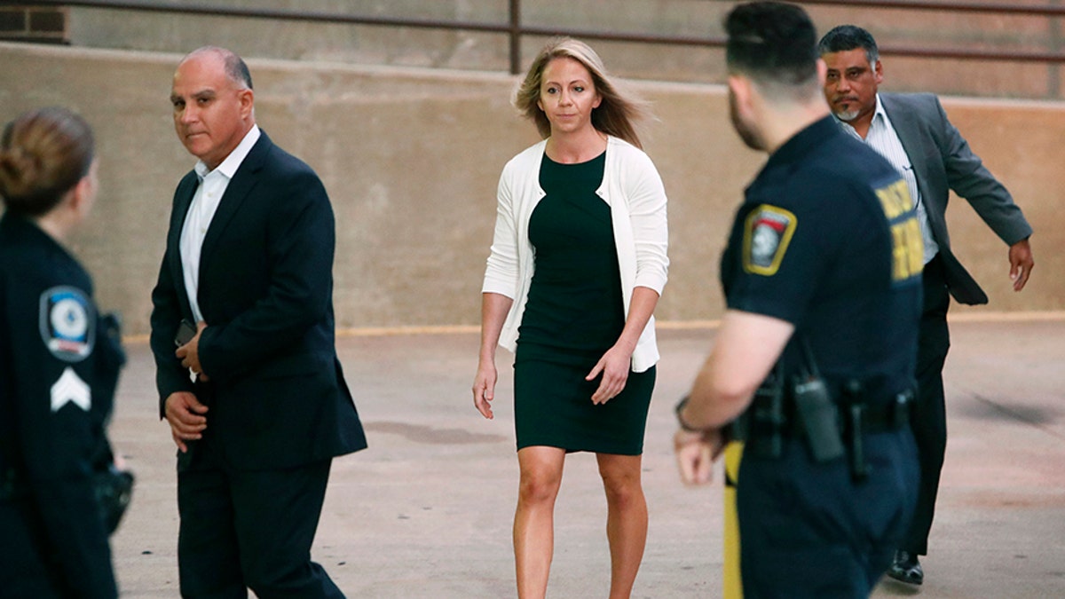 Former Dallas police officer Amber Guyger is escorted by a security detail as she arrives for her murder trial at the Frank Crowley Courthouse in downtown Dallas, Tuesday, Sept. 24, 2019. 
