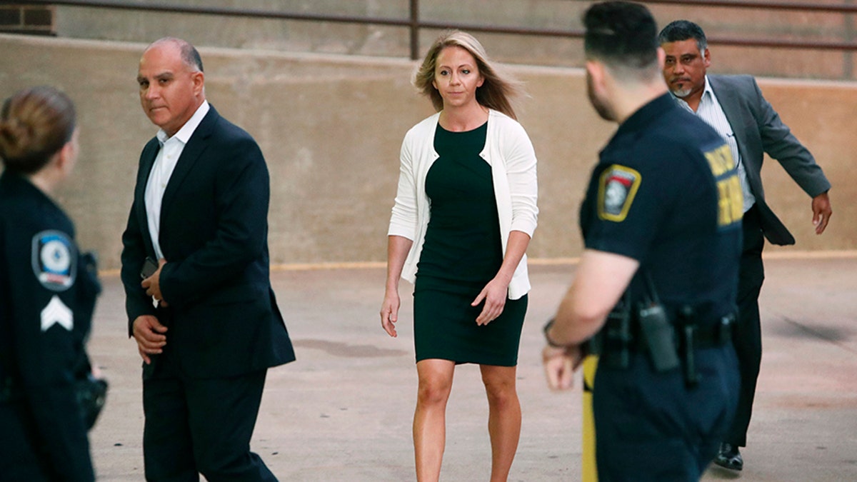 Former Dallas police officer Amber Guyger is escorted by a security detail as she arrives for her murder trial at the Frank Crowley Courthouse in downtown Dallas, Tuesday, Sept. 24, 2019.?