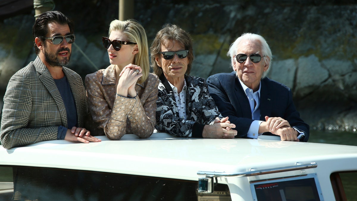 Actors Claes Bang, from left, Elizabeth Debicki, Mick Jagger or Donald Sutherland pose for photographers upon arrival for the photo call of the film 'The Burnt Orange Heresy'