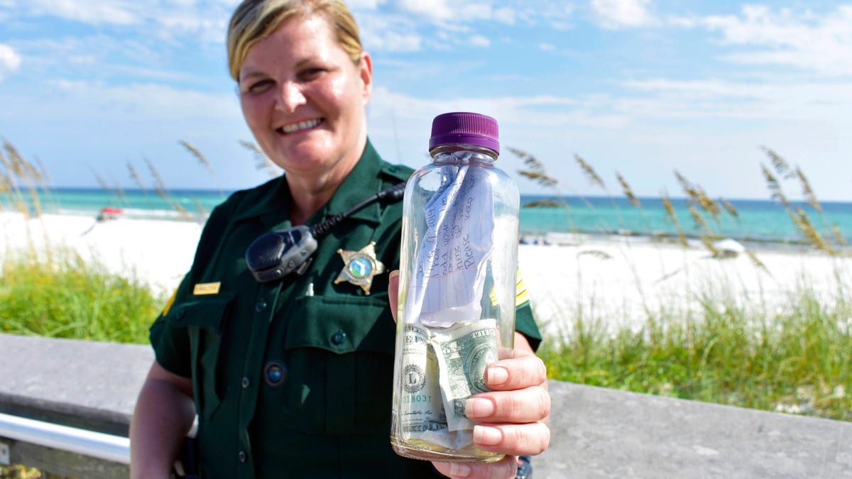 Sgt. Paula Pendleton with the Walton County Sheriff's Office, posing with the bottle that washed ashore last week near Miramar Beach, Florida.