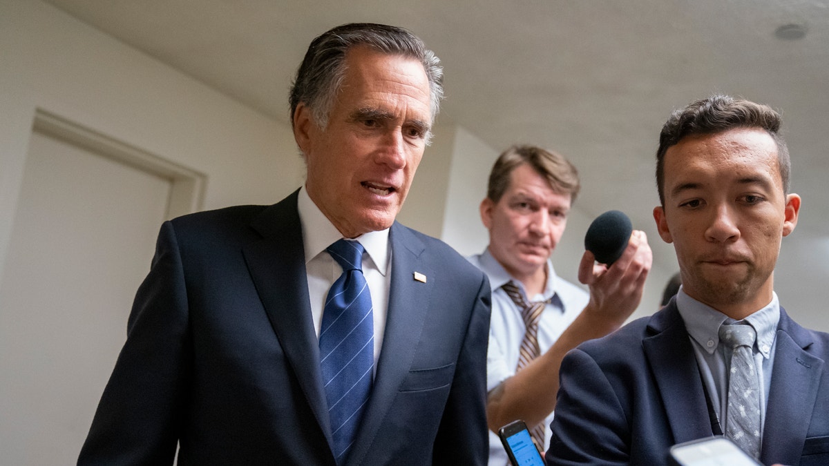 Sen. Mitt Romney, R-Utah, takes questions from reporters as he arrives for votes on pending nominations, at the Capitol in Washington, Wednesday, Sept. 11, 2019.